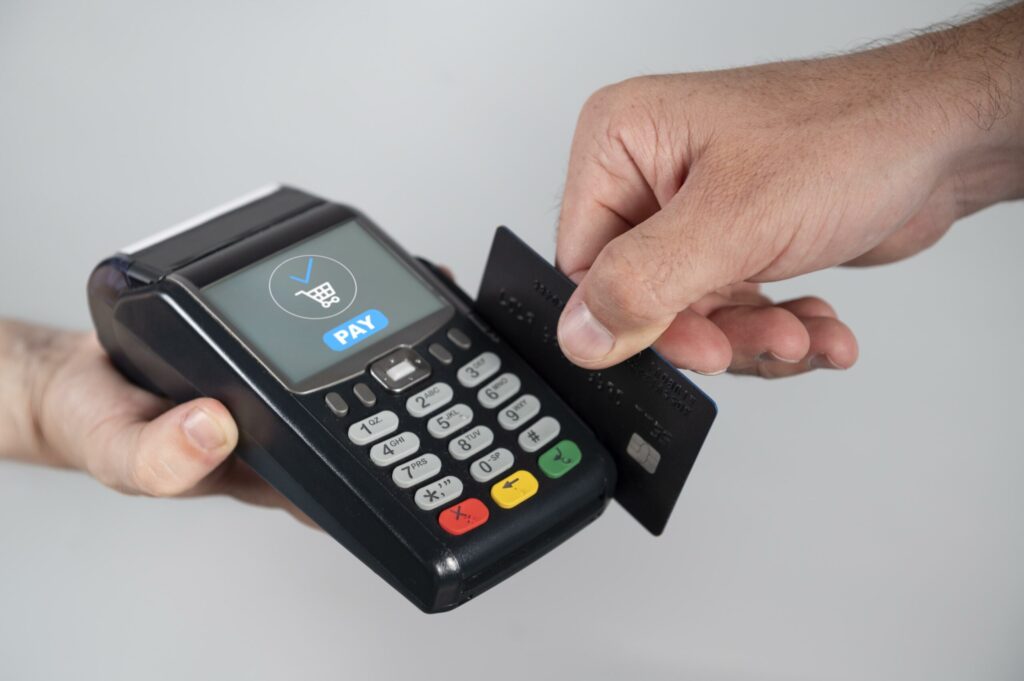 homem usando cartao de credito para pagar um produto